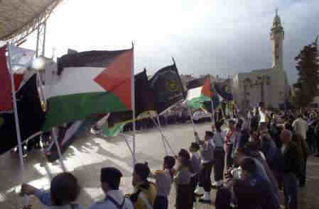 12/24-オマール Ibn al Khatas モスクを背景にクリスマスイブ行進をする