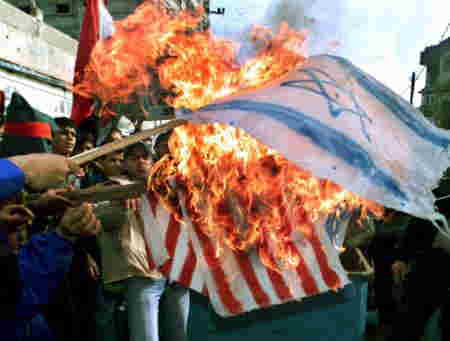 中東和平マラソン協議に反対するパレスチナ人たちがイスラエルとアメリカの国旗を燃やす